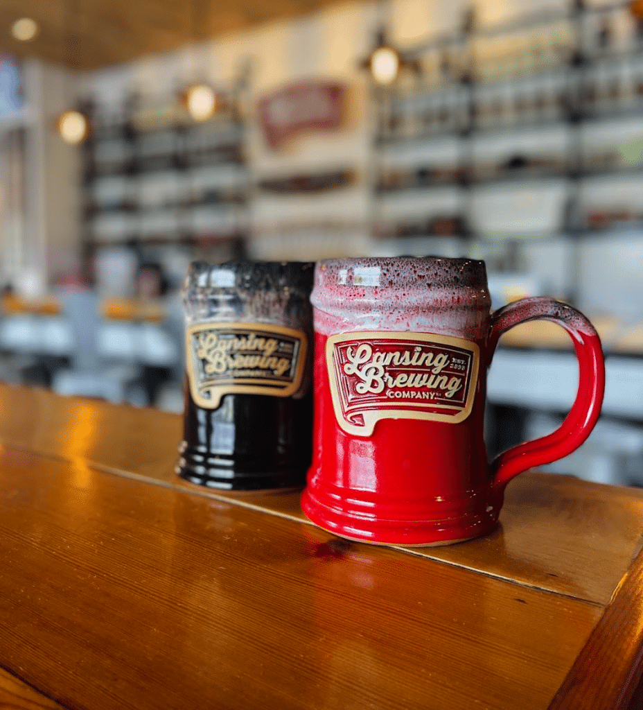 Two mugs sit on a bar at Lansing Brewing Company